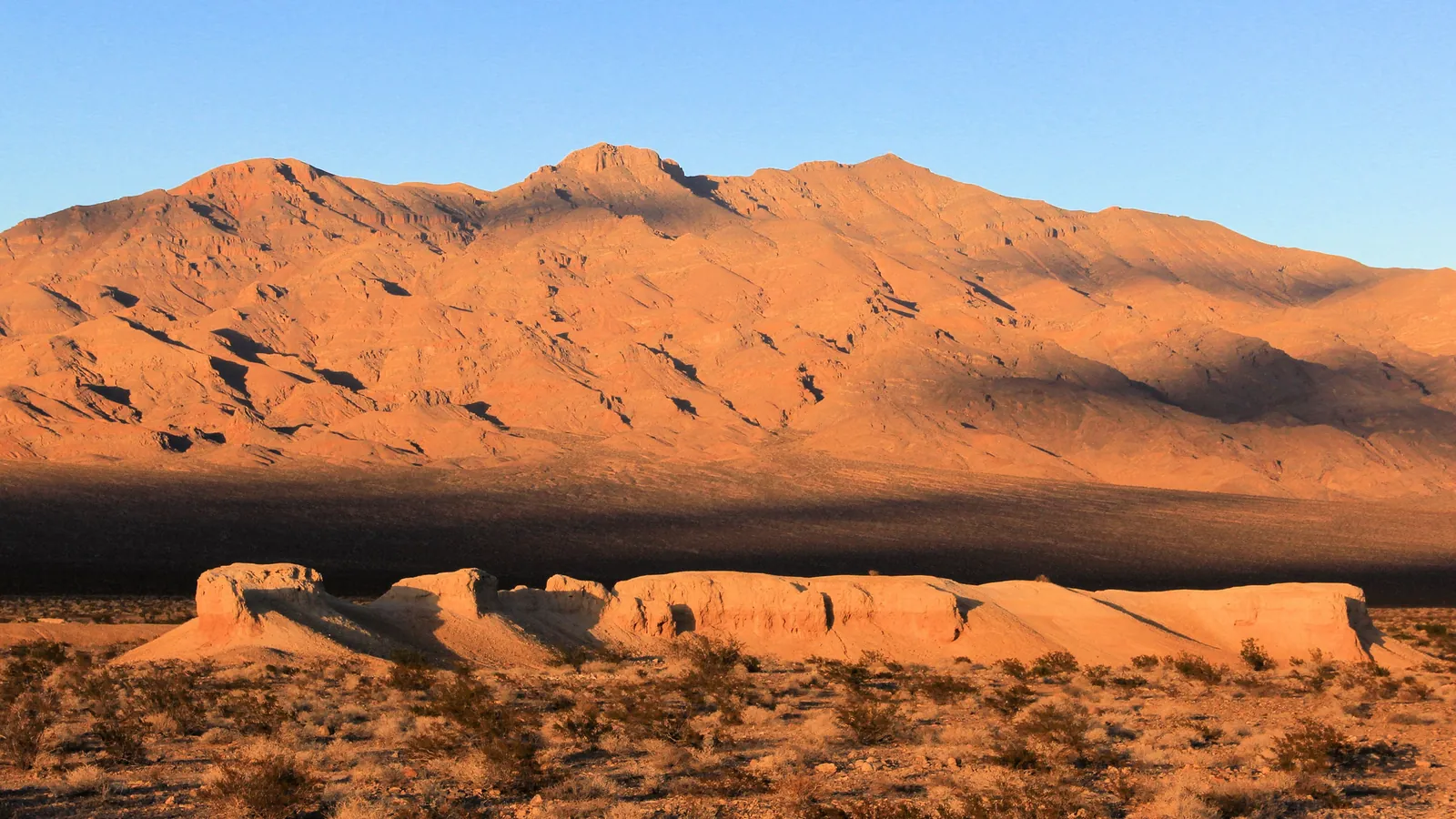 Sunlit desert hills and a rock formation at Tule Springs Fossil Beds National Monument