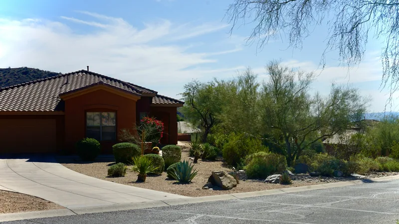 Single-story house with a tile roof, desert landscaping and a driveway