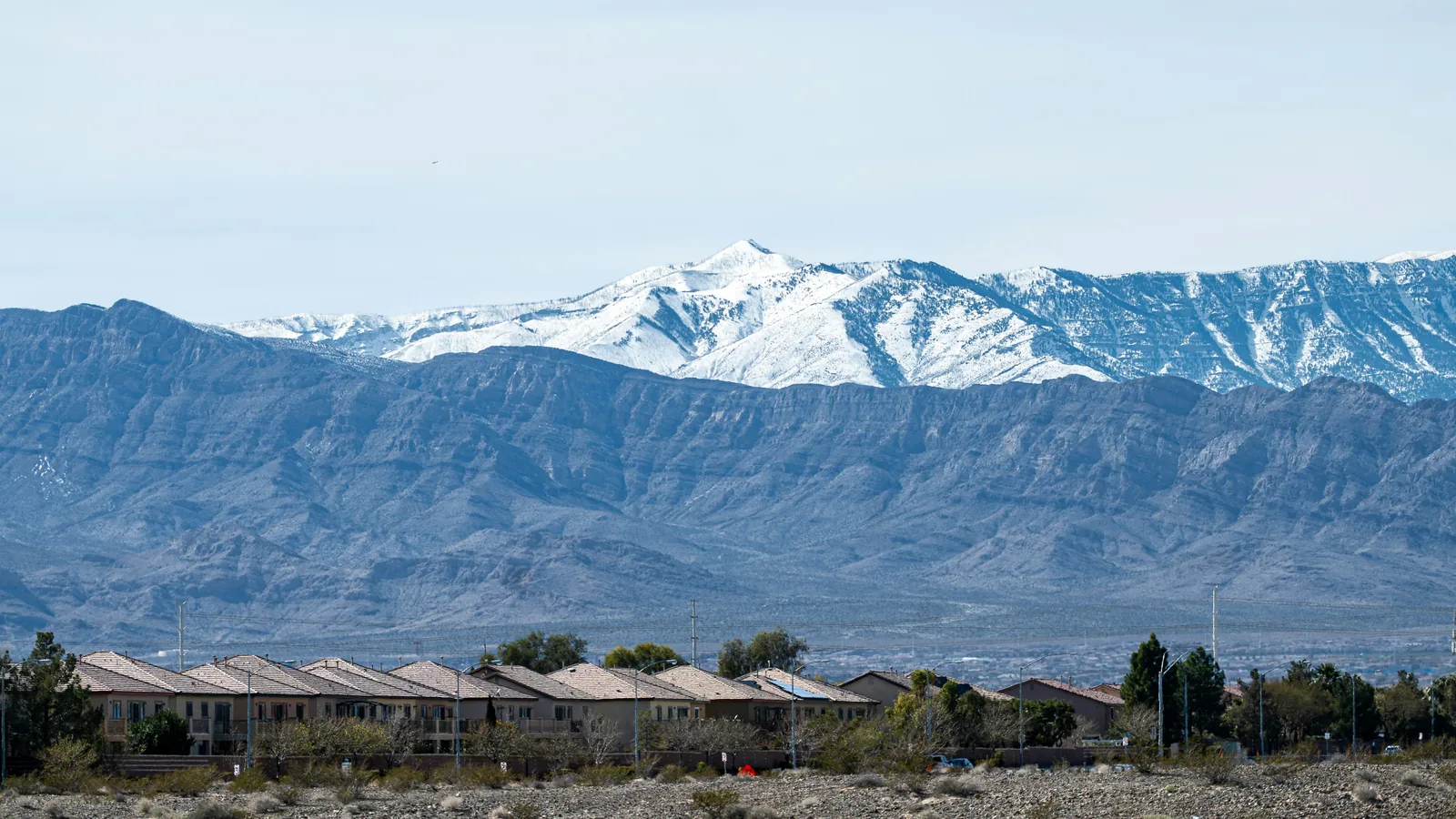 Row of attached homes with snow-capped mountains rising behind