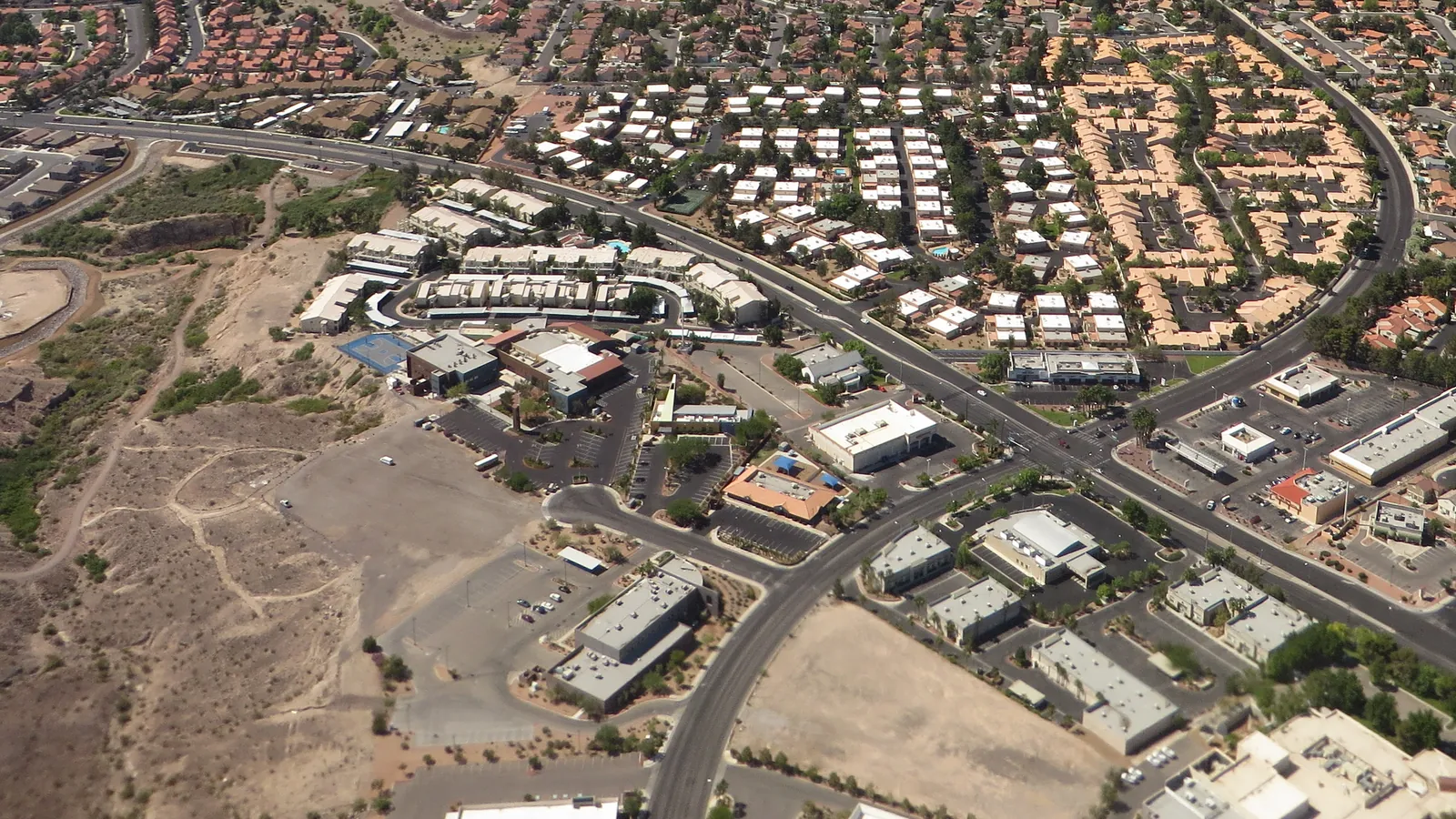 Aerial view of homes, shopping centers and roads at the edge of desert hills in the Las Vegas valley