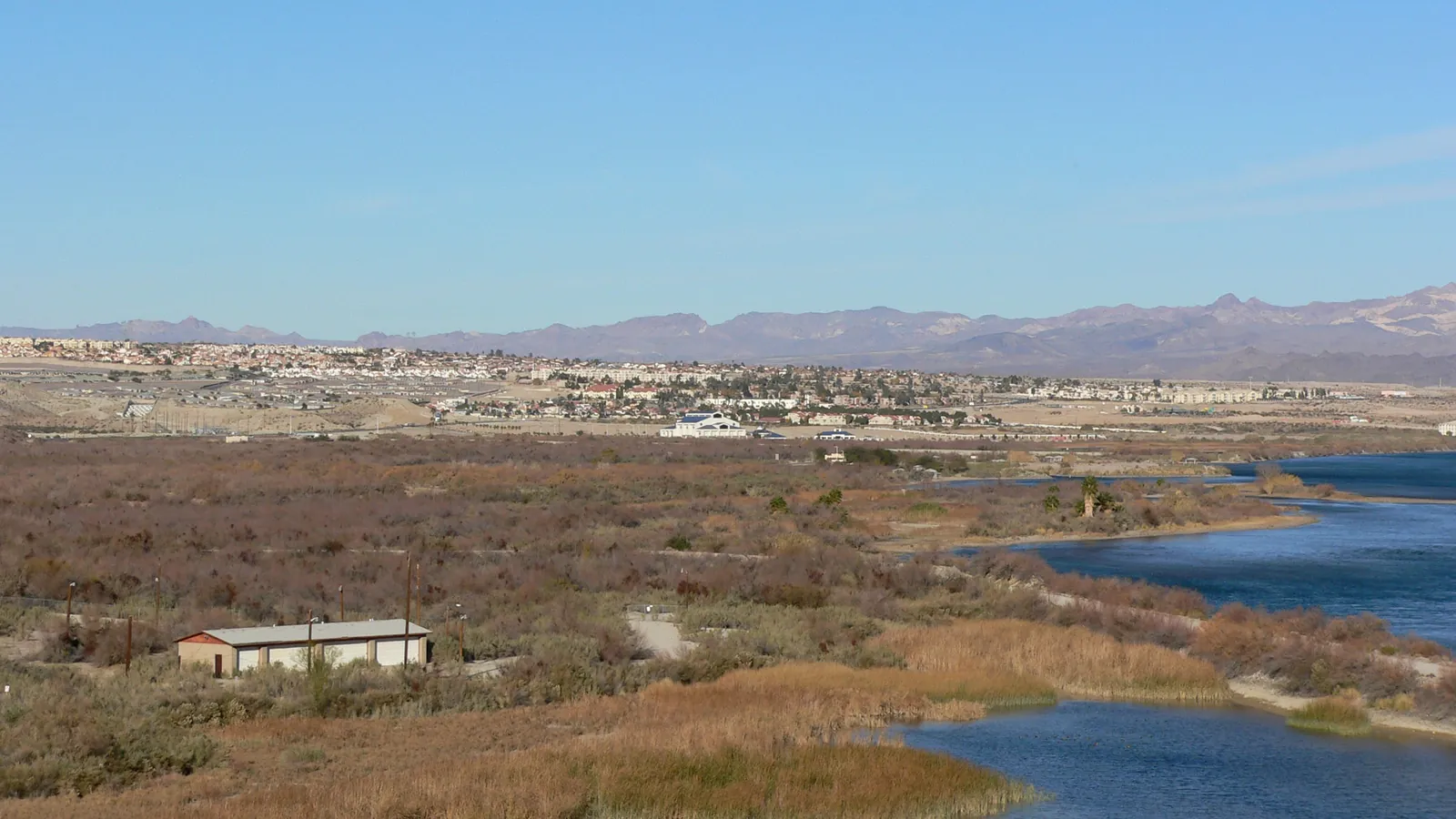 The Colorado River and desert shoreline with mountains in the distance near Laughlin, Nevada