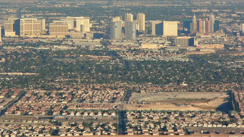 Aerial view of residential neighborhoods in the Las Vegas Valley with the Strip skyline in the distance